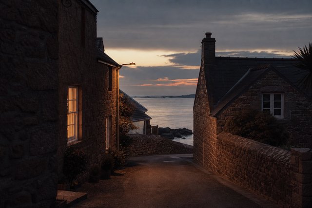 A quiet granite lane on Alderney in the Channel Islands at dusk